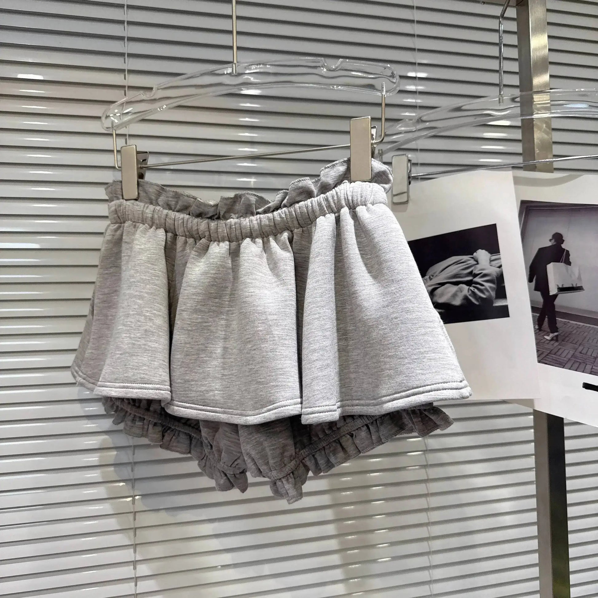 Layered Ruffle Drawstring Mini Skort displayed on a hanger, showcasing its ruffled design and elastic waistband.
