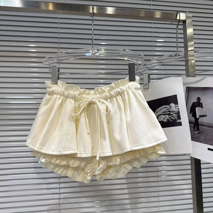 Layered Ruffle Drawstring Mini Skort in cream color hanging on display.