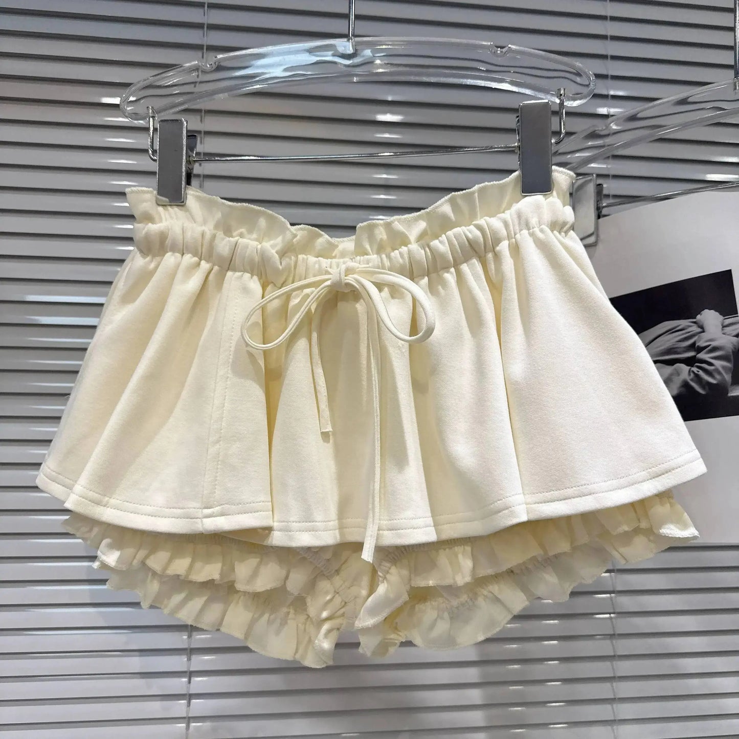 Layered Ruffle Drawstring Mini Skort in cream color with elastic waistband and ruffle details.