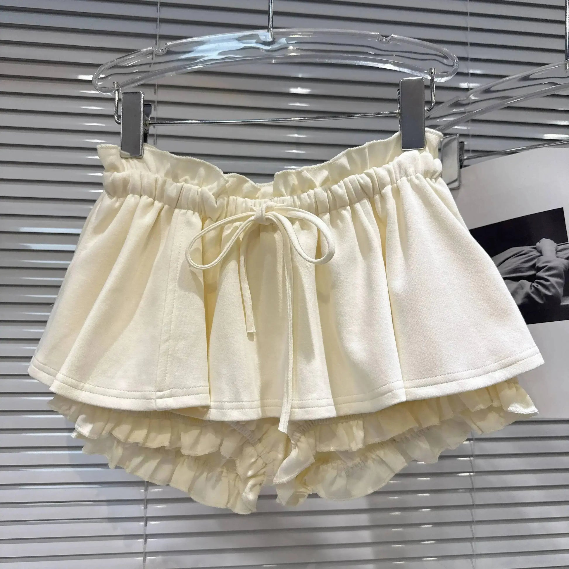 Layered Ruffle Drawstring Mini Skort in cream color with elastic waistband and ruffle details.