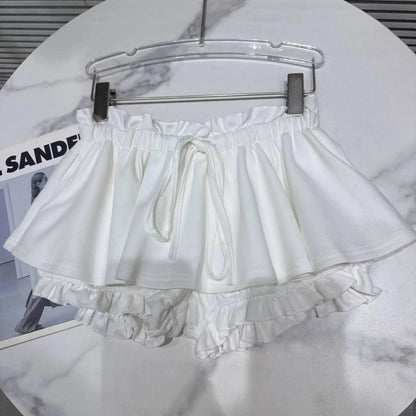 Layered Ruffle Drawstring Mini Skort in white hanging on a rack, showcasing its playful and feminine design.