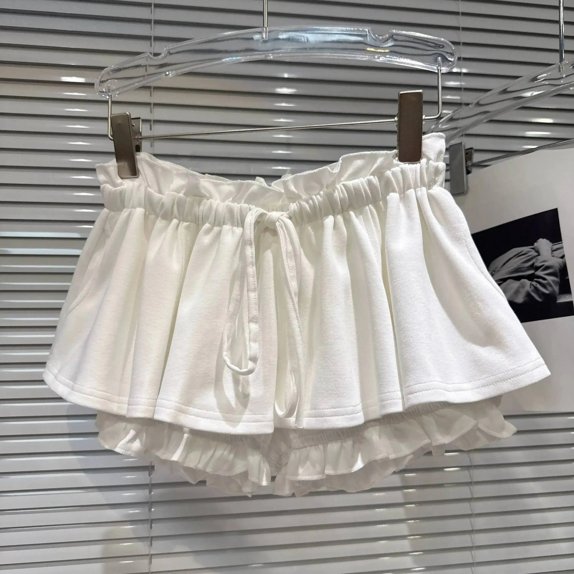 Layered Ruffle Drawstring Mini Skort hanging display in white, showcasing layered ruffles and drawstring detail.