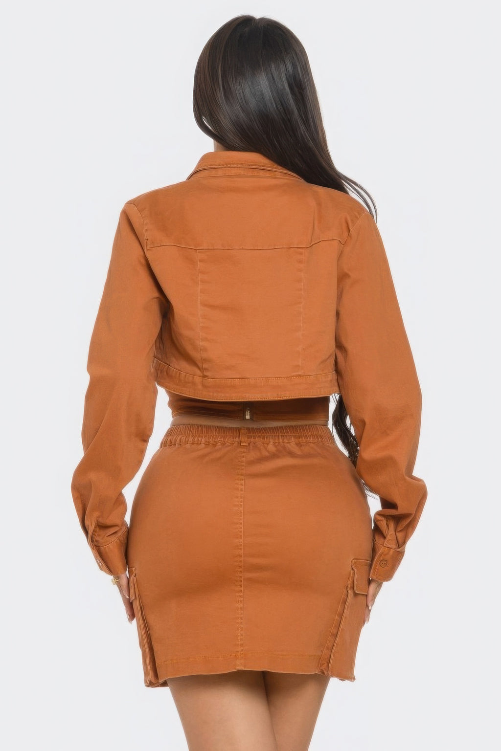 Stylish three piece skirt set featuring a fitted skirt, chic top, and matching crop jacket in a warm orange color.