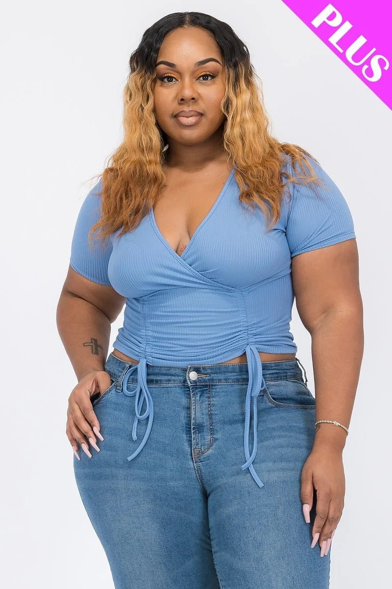 Plus-size model wearing a wrap tie v-neck fitted shirt in blue, showcasing the flattering design and adjustable tie detail.