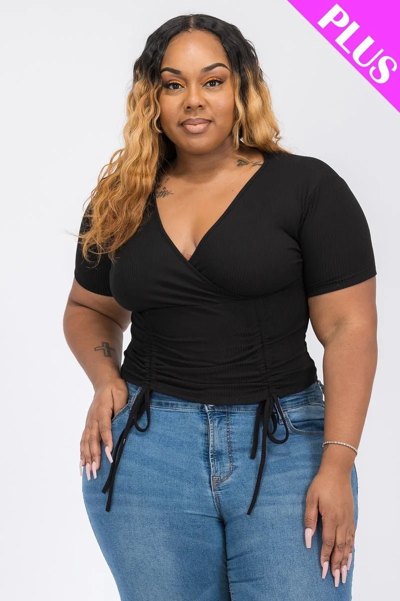 Plus size model wearing a wrap tie v-neck fitted shirt in black, showcasing adjustable side ties and a flattering fit.
