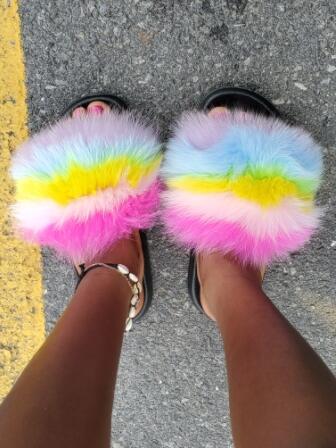 Colorful plush faux fur slides with a rainbow design, perfect for adding style and comfort to any outfit.