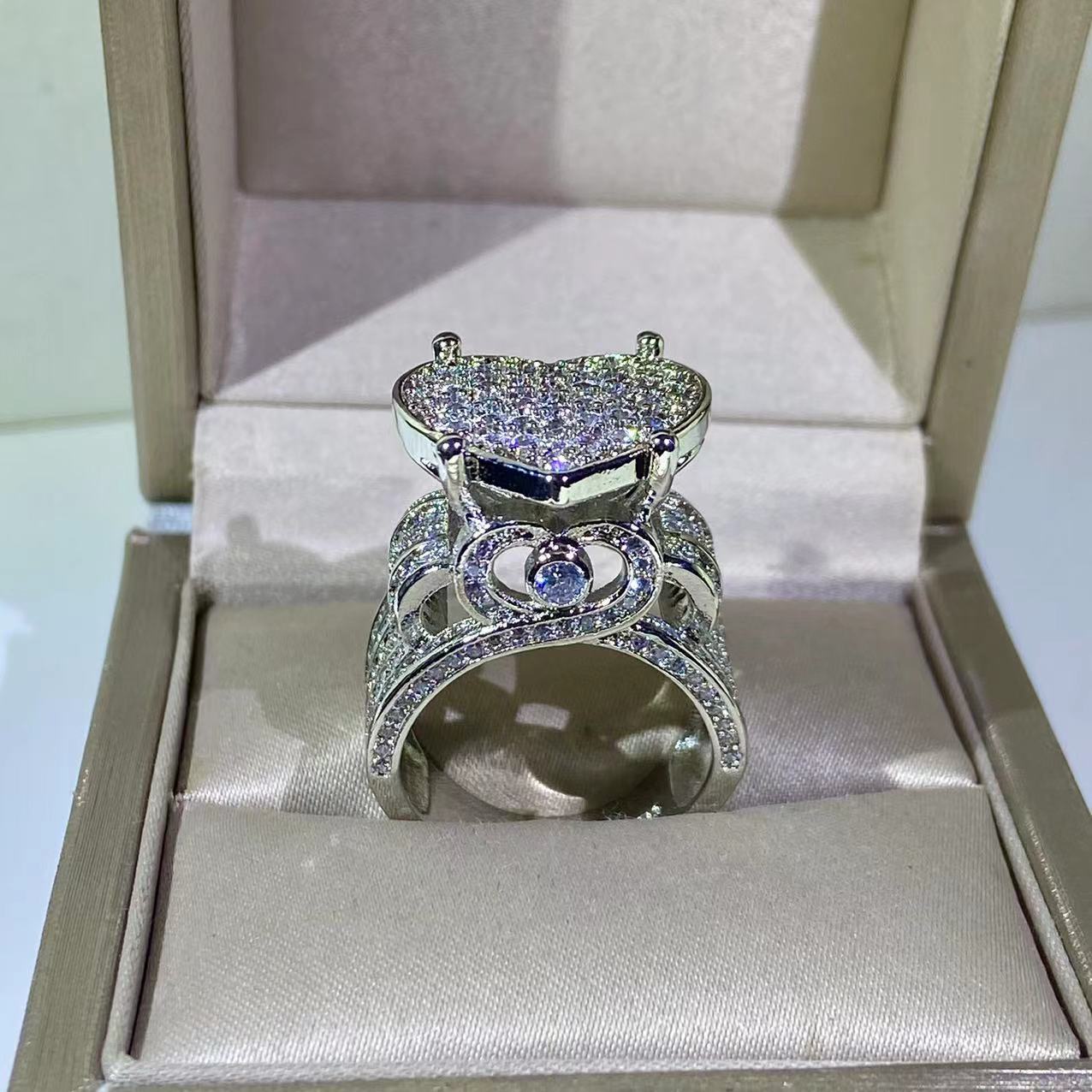 Heart-shaped zircon ring showcased in a luxurious box, featuring a sparkling prong setting and silver band.