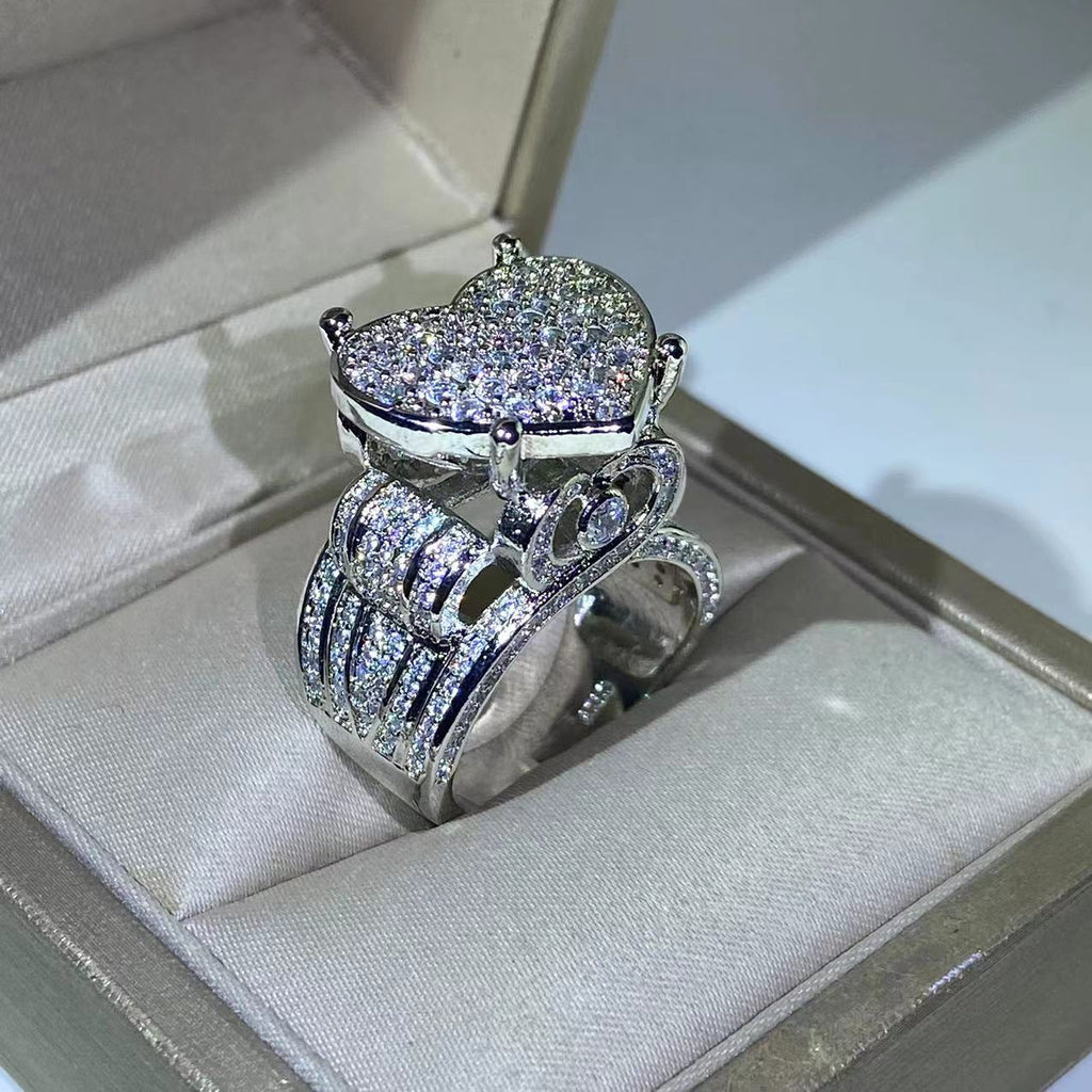 Heart-shaped zircon ring with dazzling prong setting in silver on display in a jewelry box.